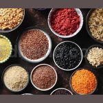 various superfoods in smal bowls on dark rusty bac