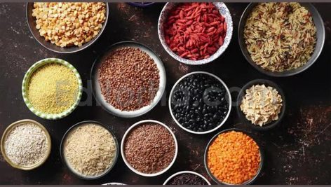 various superfoods in smal bowls on dark rusty bac