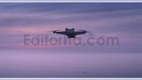 The Quadcopter Hovered in the Air Against the Backdrop of the Sea and a Beautiful Pink Sunset The