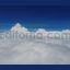 Flying above soft fluffy white cotton clouds against blue sky