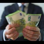 Formally Dressed Man Counting Euro Banknotes