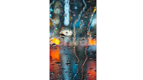 Lights of the Evening City and Passing Cars Through a Wet Rainy Window