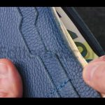 A Closeup View of Cash Being Stored in a Blue Wallet for Financial Purposes